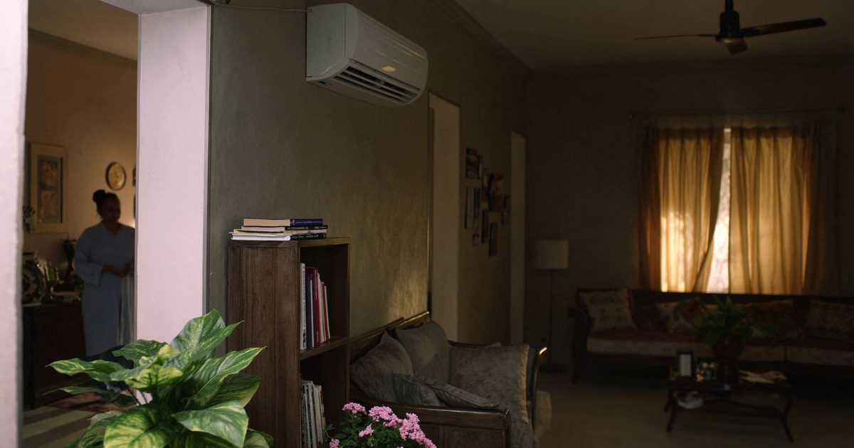 Wall-mounted split air conditioner in the living room of an Indian family home