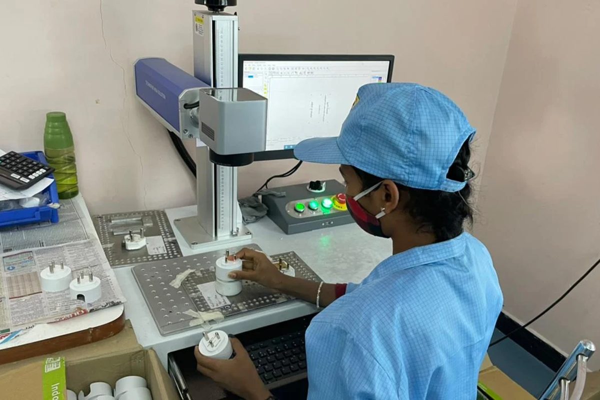 An operator placing a moulded part under a laser marking head